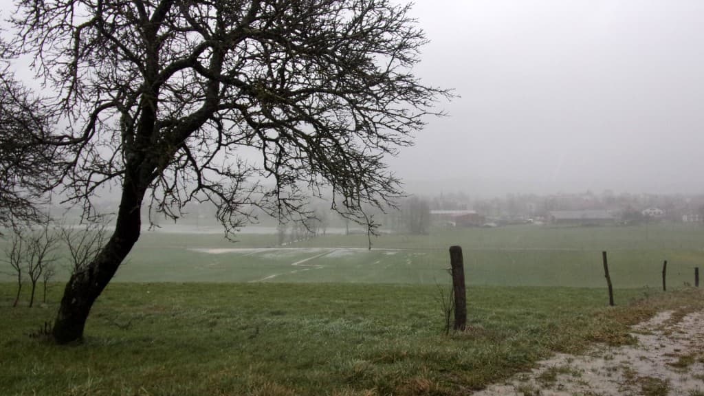 Rideau de pluie et prés inondés