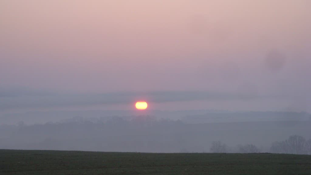 Nuage de fumée devant le soleil levant